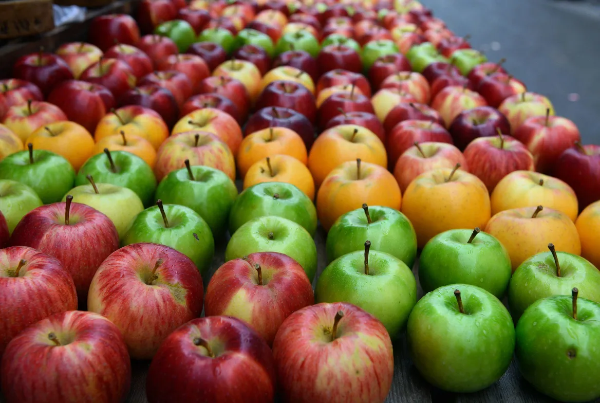 Rows of shiny, crisp apples neatly displayed in a supermarket produce aisle, looking perfectly fresh year-round